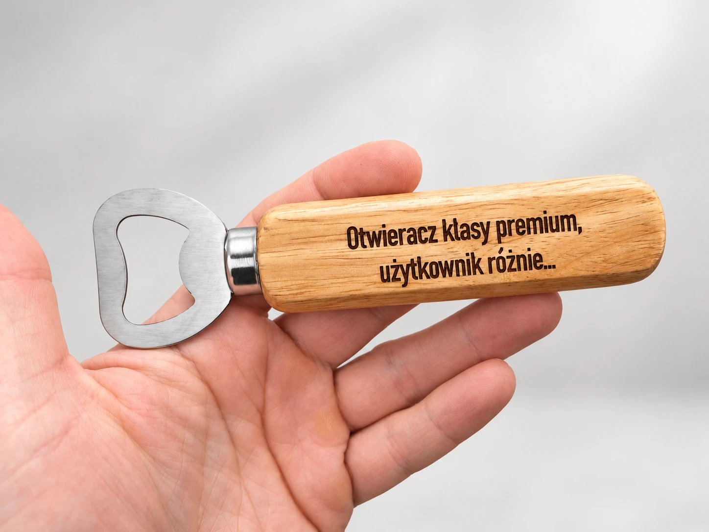Otwieracz do butelek z drewnianą rączką i grawerem Otwieracz klasy premium, użytkownik różnie — trzymany w dłoni